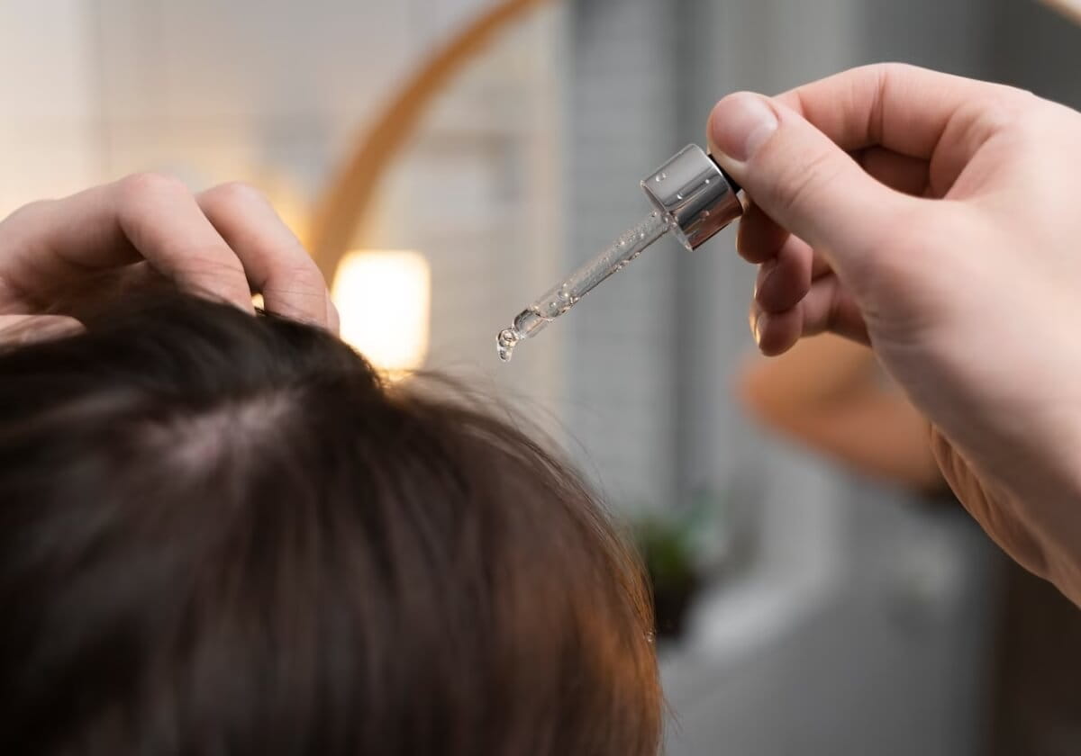 pessoa aplicando sérum capilar