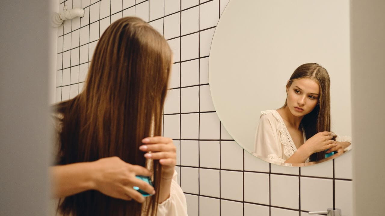 mulher usando Cadiveu Professional Glamour Rubi Shampoo